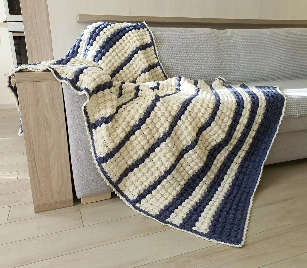handmade crochet throw blanket in blended wool with intricate patterns.