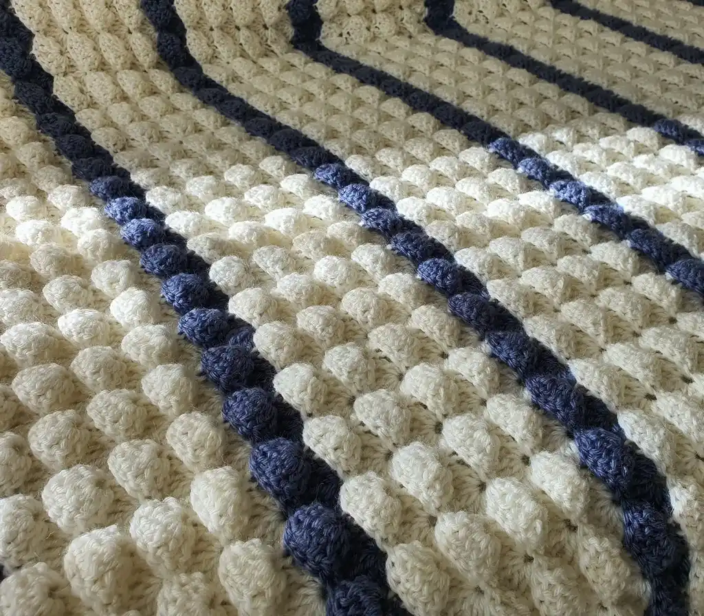 handmade crochet throw blanket in blended wool with intricate patterns.