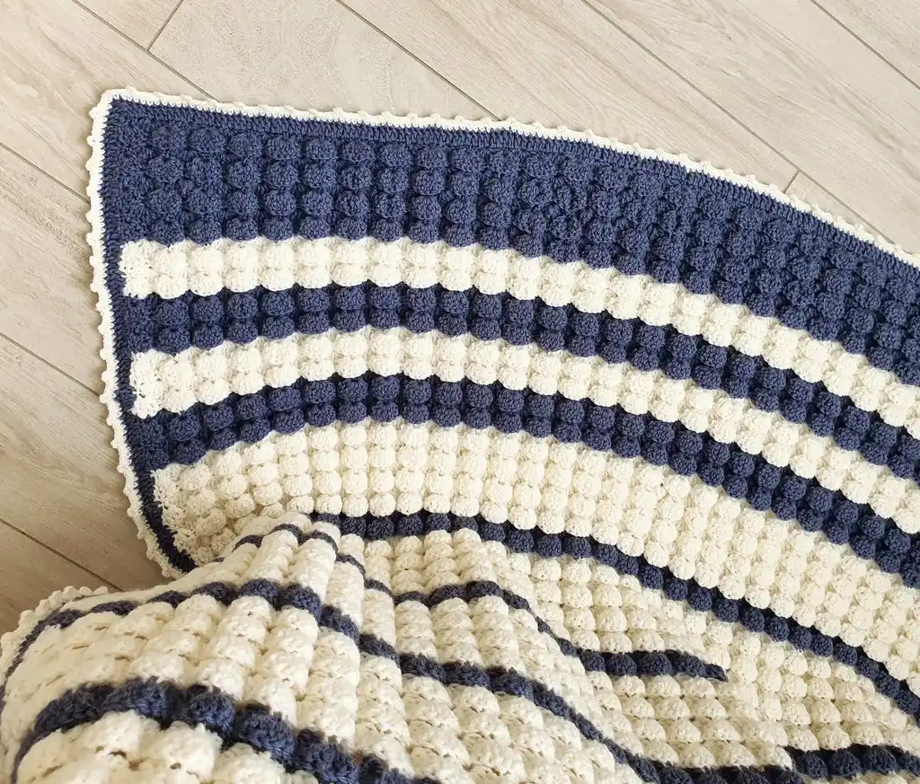 handmade crochet throw blanket in blended wool with intricate patterns.