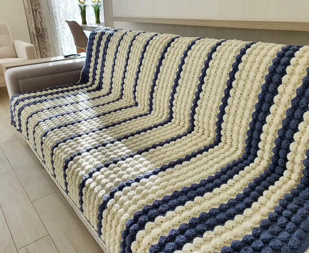 handmade crochet throw blanket in blended wool with intricate patterns.