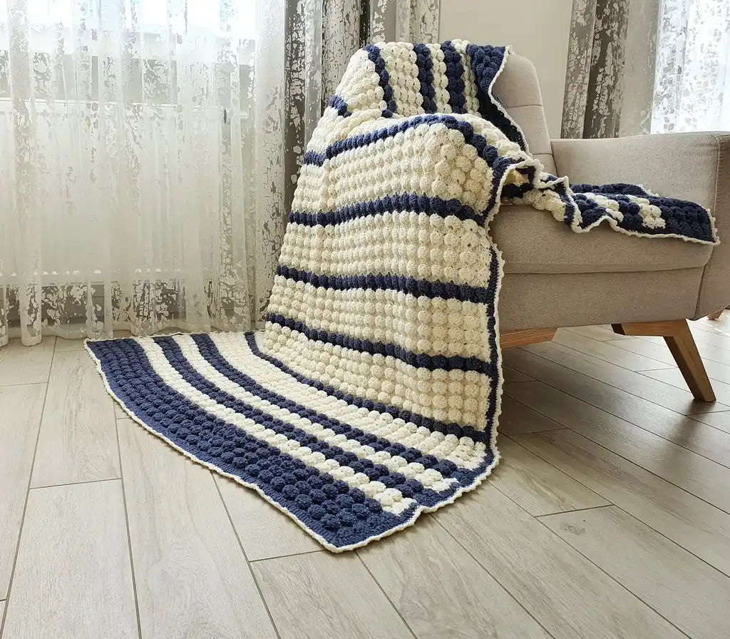 handmade crochet throw blanket in blended wool with intricate patterns.