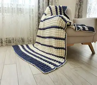handmade crochet throw blanket in blended wool with intricate patterns.