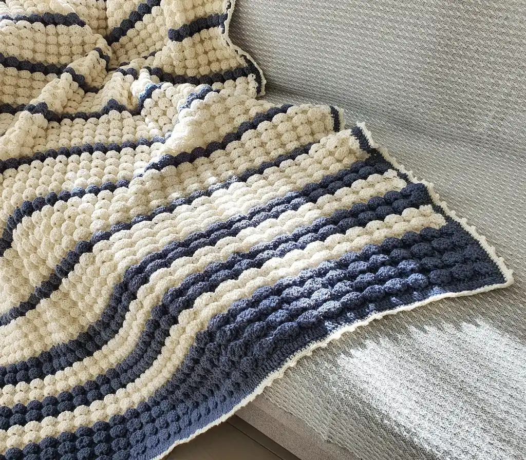 handmade crochet throw blanket in blended wool with intricate patterns.