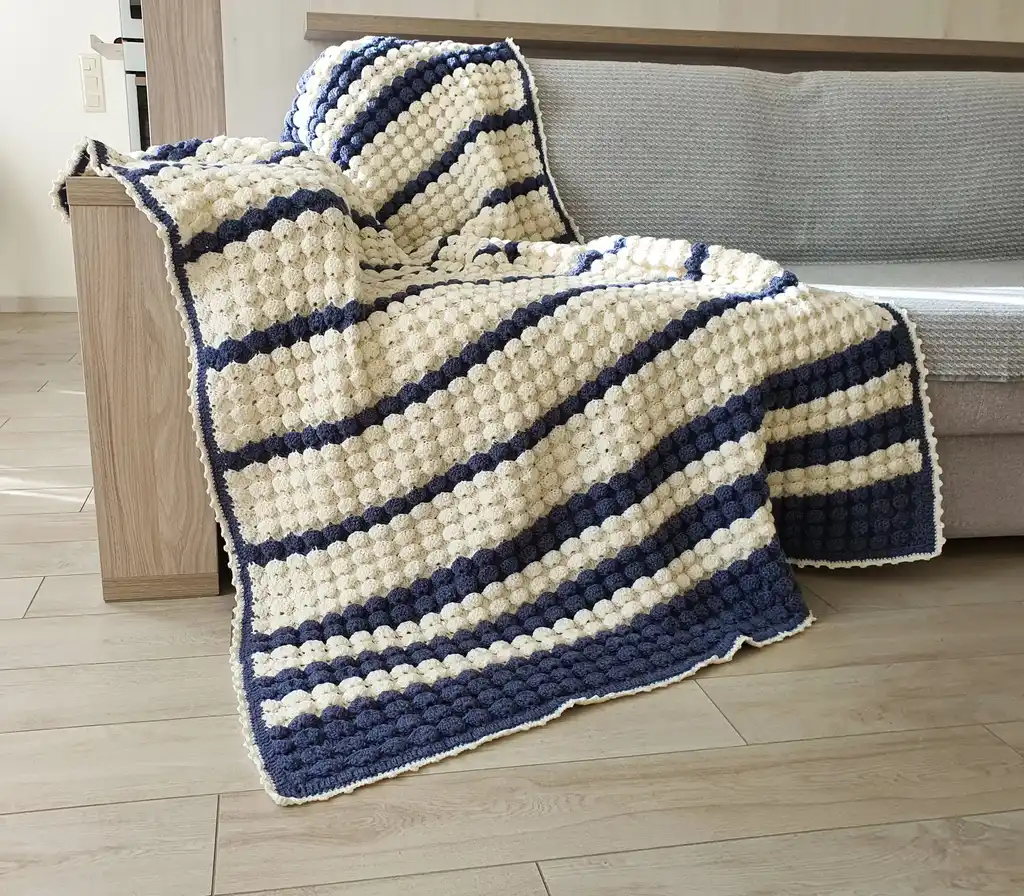 handmade crochet throw blanket in blended wool with intricate patterns.