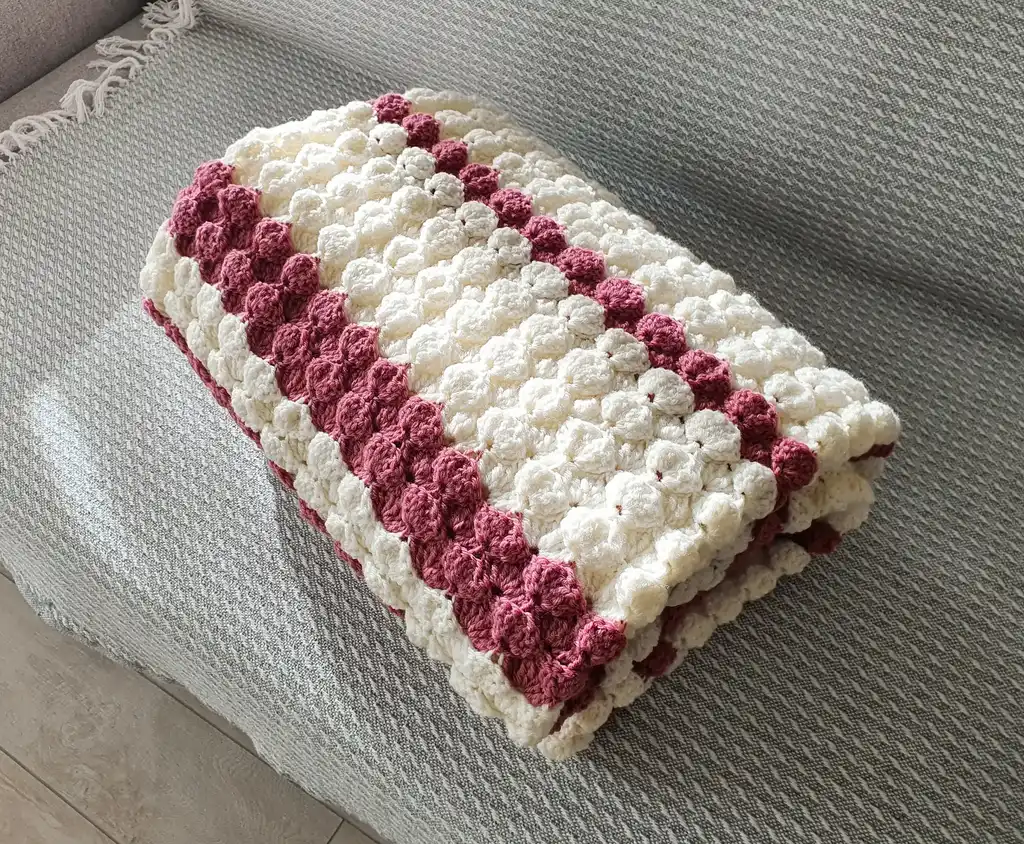 handcrafted crochet throw blanket in blended wool with intricate patterns.