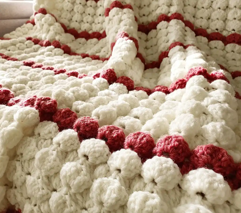 handcrafted crochet throw blanket in blended wool with intricate patterns.
