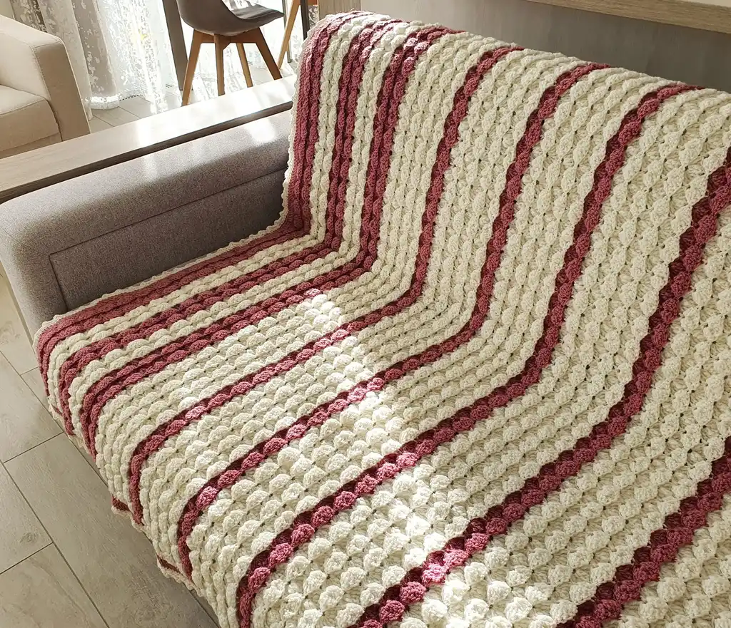 handcrafted crochet throw blanket in blended wool with intricate patterns.