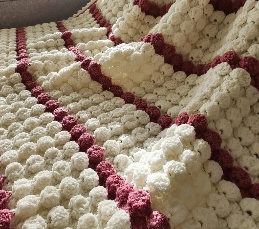 handcrafted crochet throw blanket in blended wool with intricate patterns.