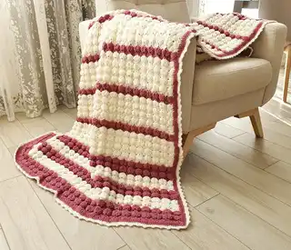 handcrafted crochet throw blanket in blended wool with intricate patterns.