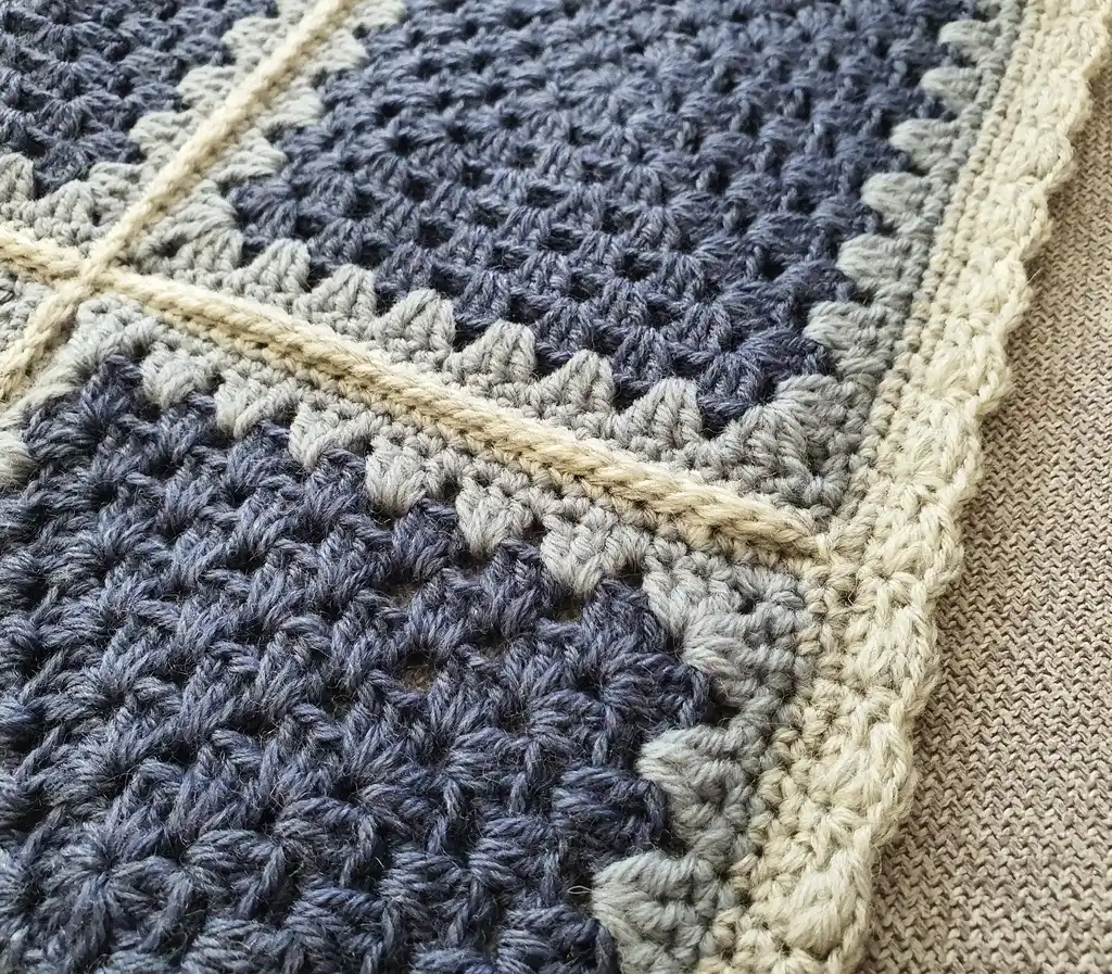 Crochet wool throw blanket in natural tones.