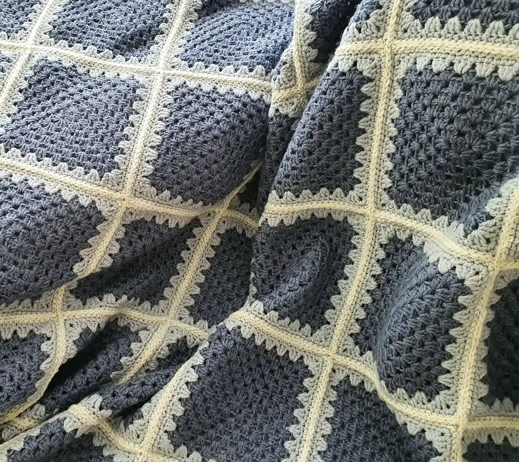 Crochet wool throw blanket in natural tones.