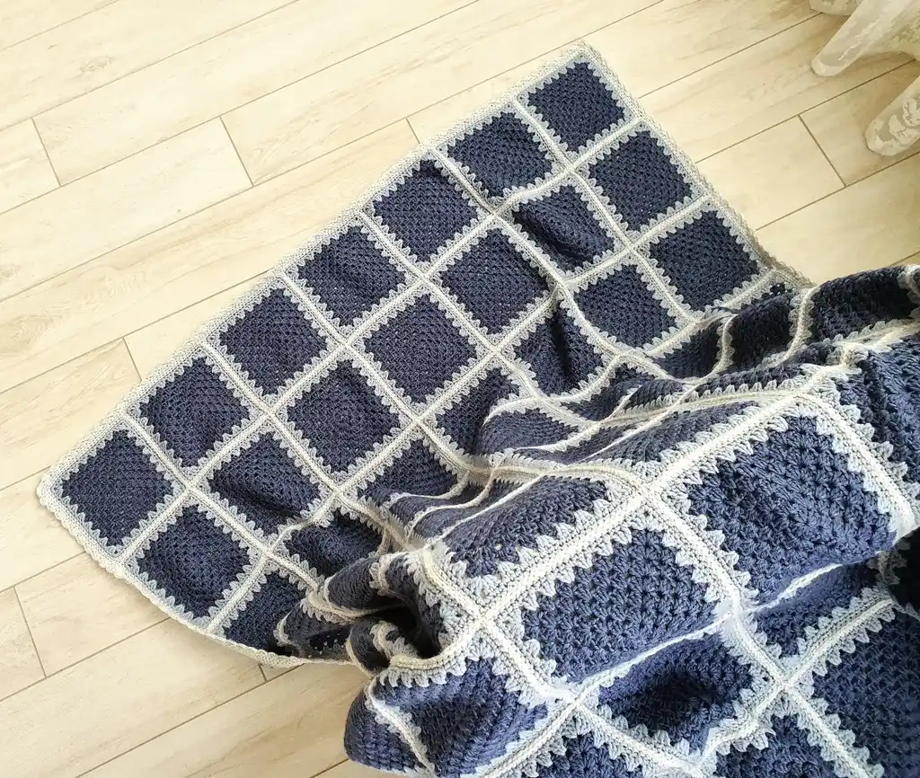 Crochet wool throw blanket in natural tones.