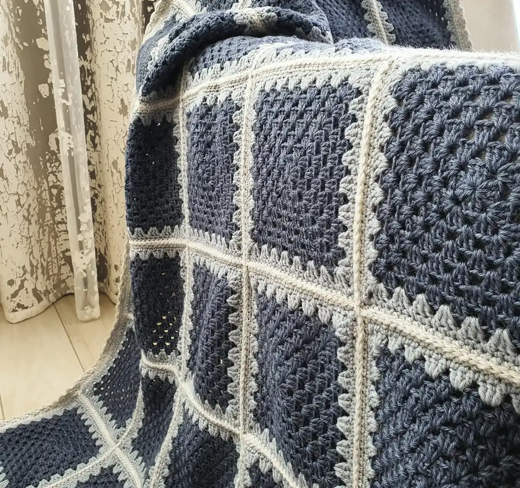 Crochet wool throw blanket in natural tones.