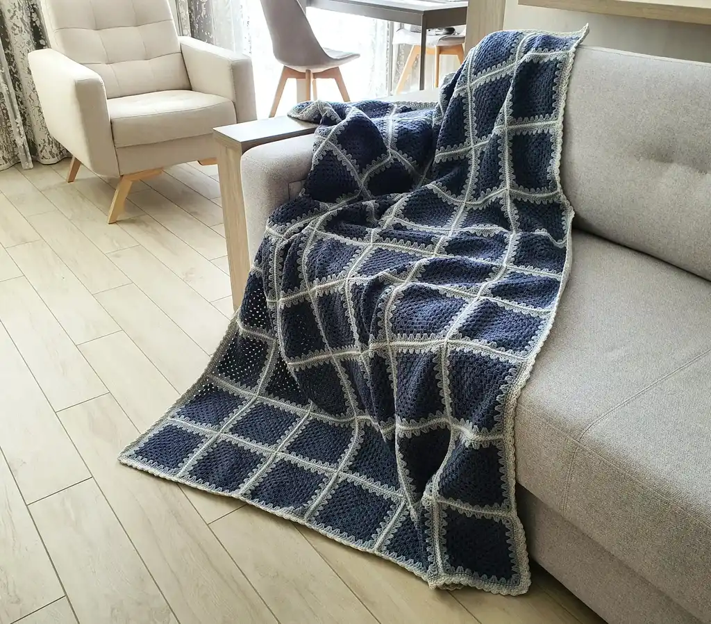 Crochet wool throw blanket in natural tones.