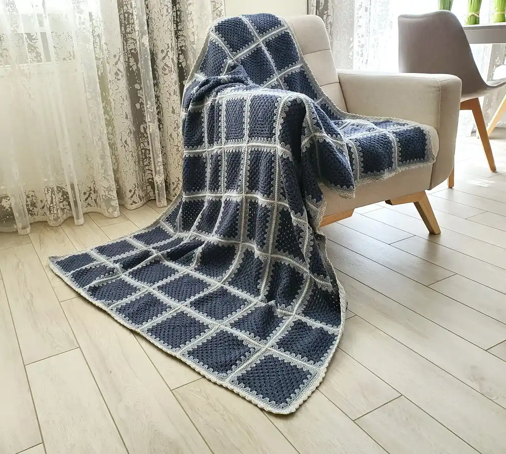 Crochet wool throw blanket in natural tones.