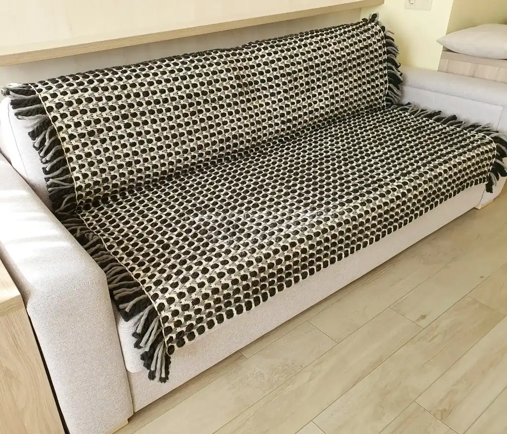Handmade crochet blanket in chunky merino wool with textured pattern.