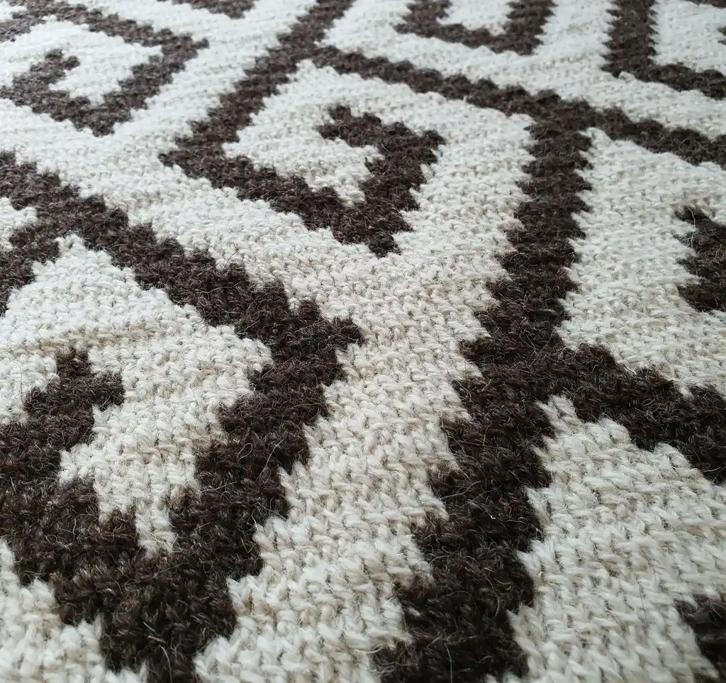Crochet wool rug in natural colors, showing detailed texture and craftsmanship.