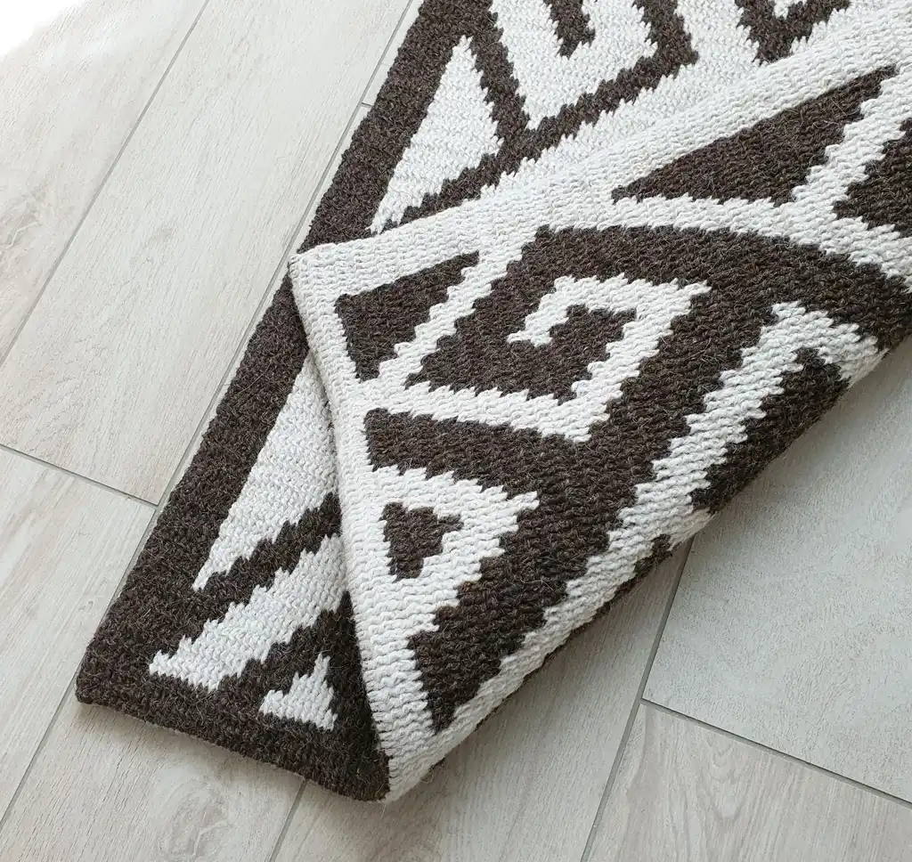 Crochet wool rug in natural colors, showing detailed texture and craftsmanship.
