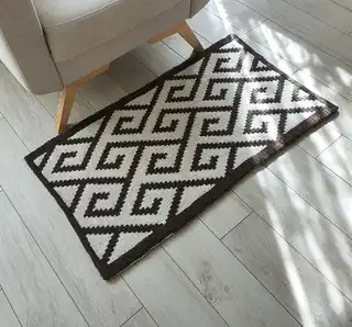 Crochet wool rug in natural colors, showing detailed texture and craftsmanship.