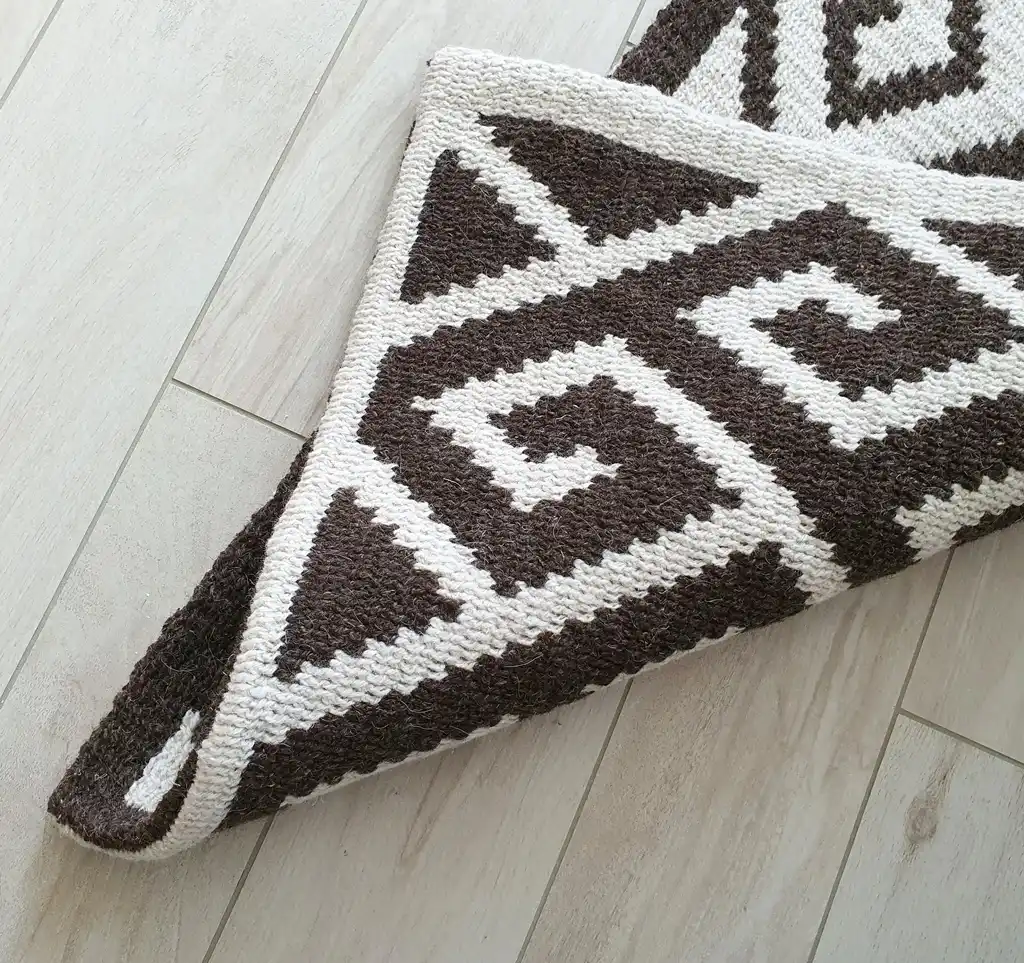 Crochet wool rug in natural colors, showing detailed texture and craftsmanship.