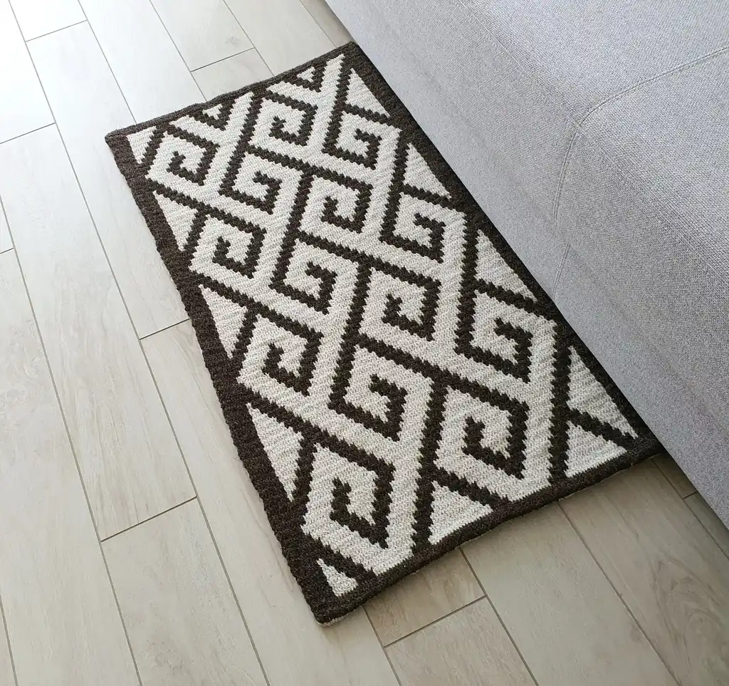Crochet wool rug in natural colors, showing detailed texture and craftsmanship.