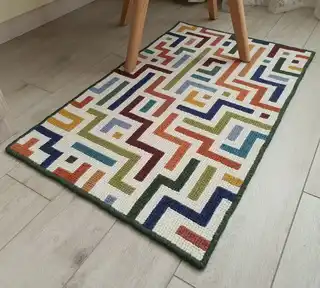 handcrafted embroidered wool rug with intricate traditional patterns.