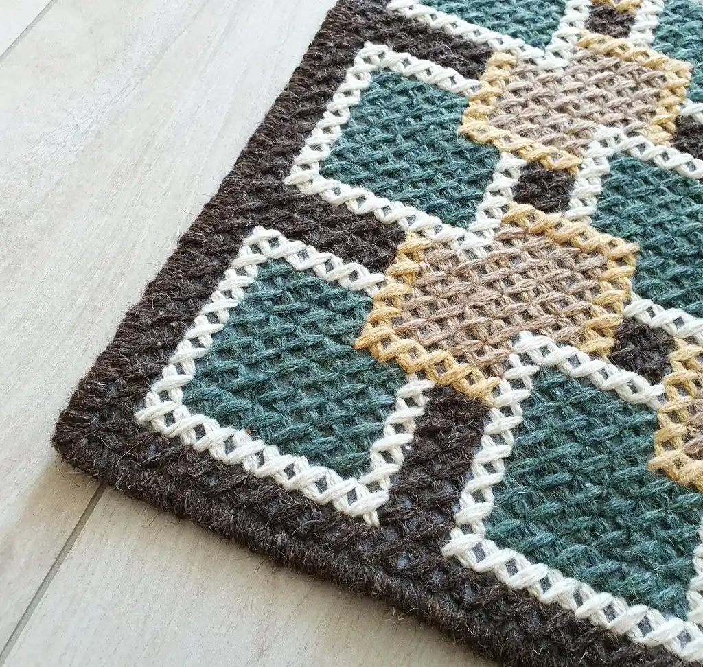 handmade cross-stitch rug made from wool and artificial felt, decorative floor covering.
