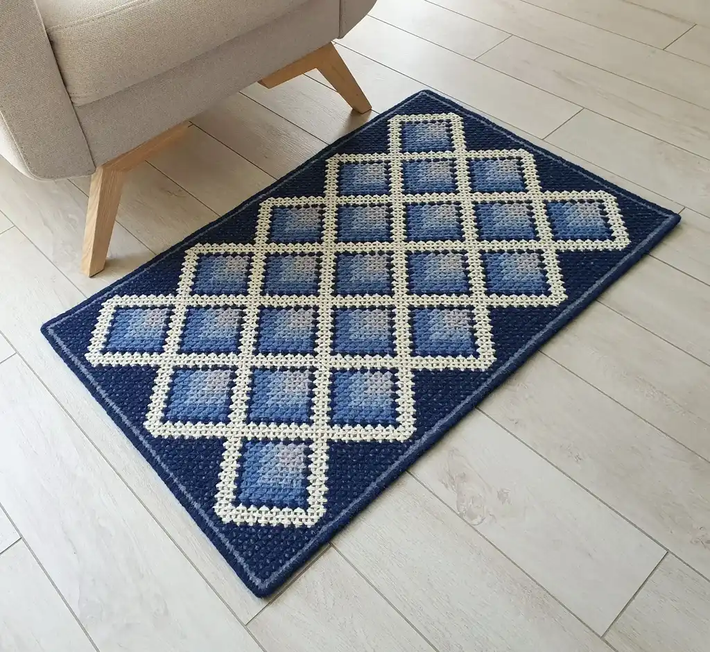 handcrafted cross-stitch wool rug on felt base with traditional patterns.