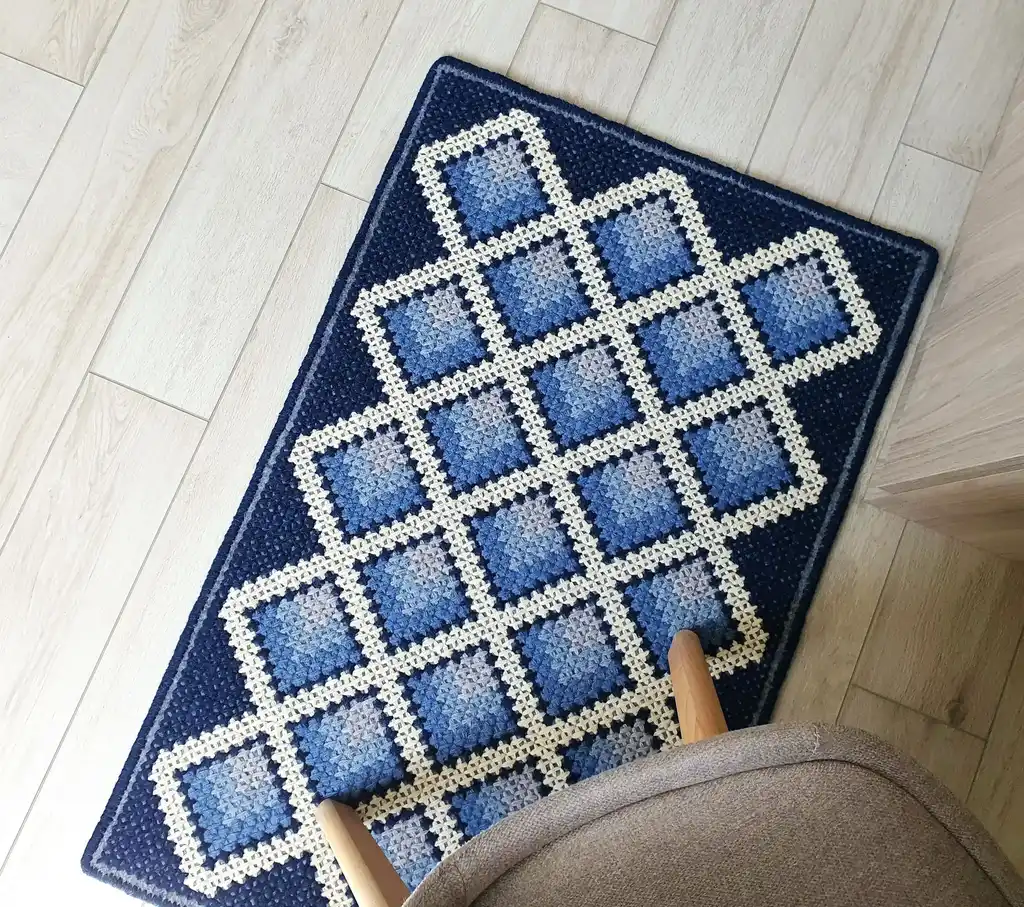 handcrafted cross-stitch wool rug on felt base with traditional patterns.
