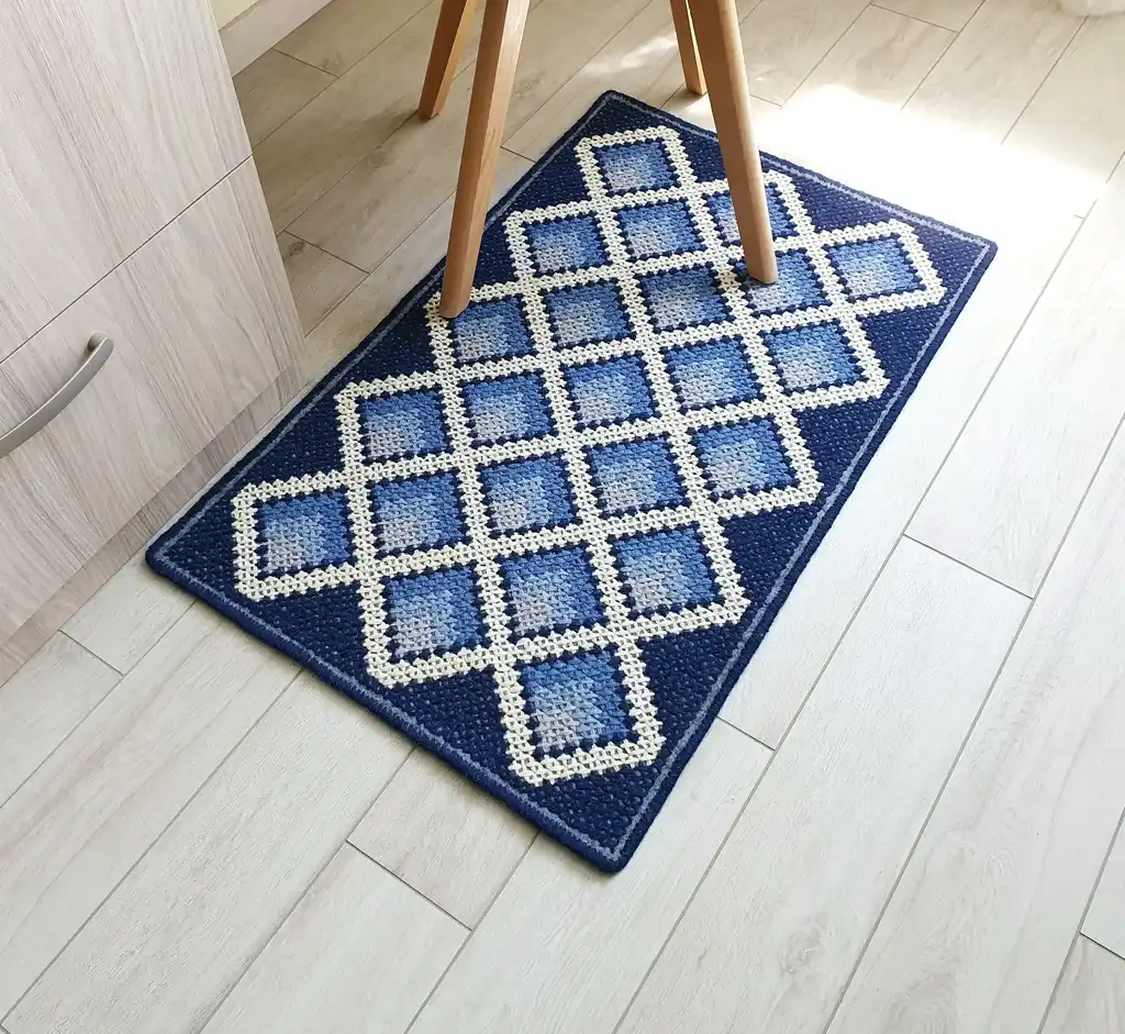 handcrafted cross-stitch wool rug on felt base with traditional patterns.