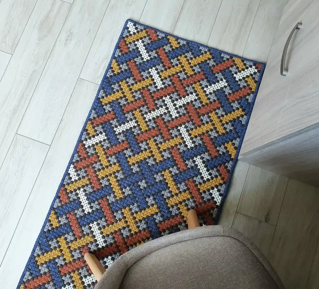 Handcrafted cross-stitch rug made from wool and felt, showcasing intricate embroidery patterns.