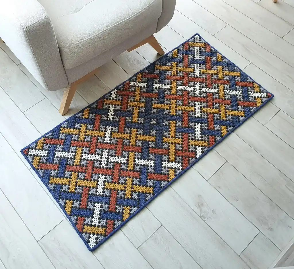 Handcrafted cross-stitch rug made from wool and felt, showcasing intricate embroidery patterns.