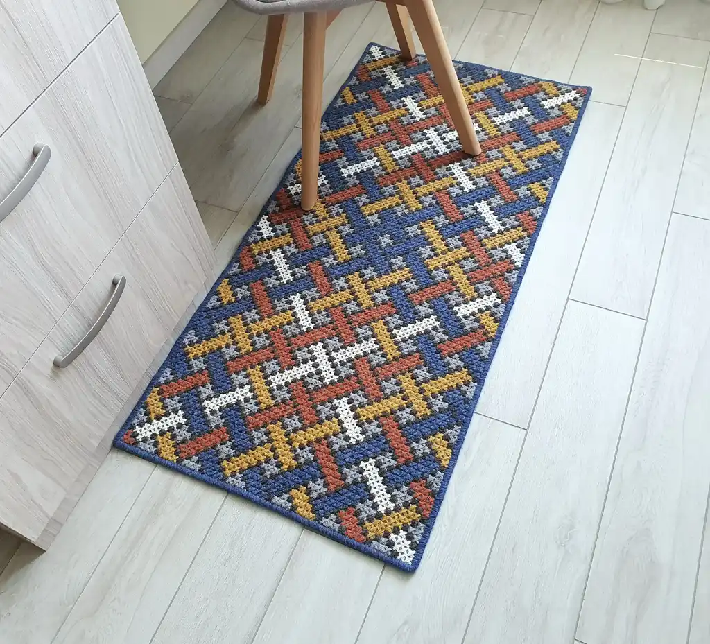 Handcrafted cross-stitch rug made from wool and felt, showcasing intricate embroidery patterns.