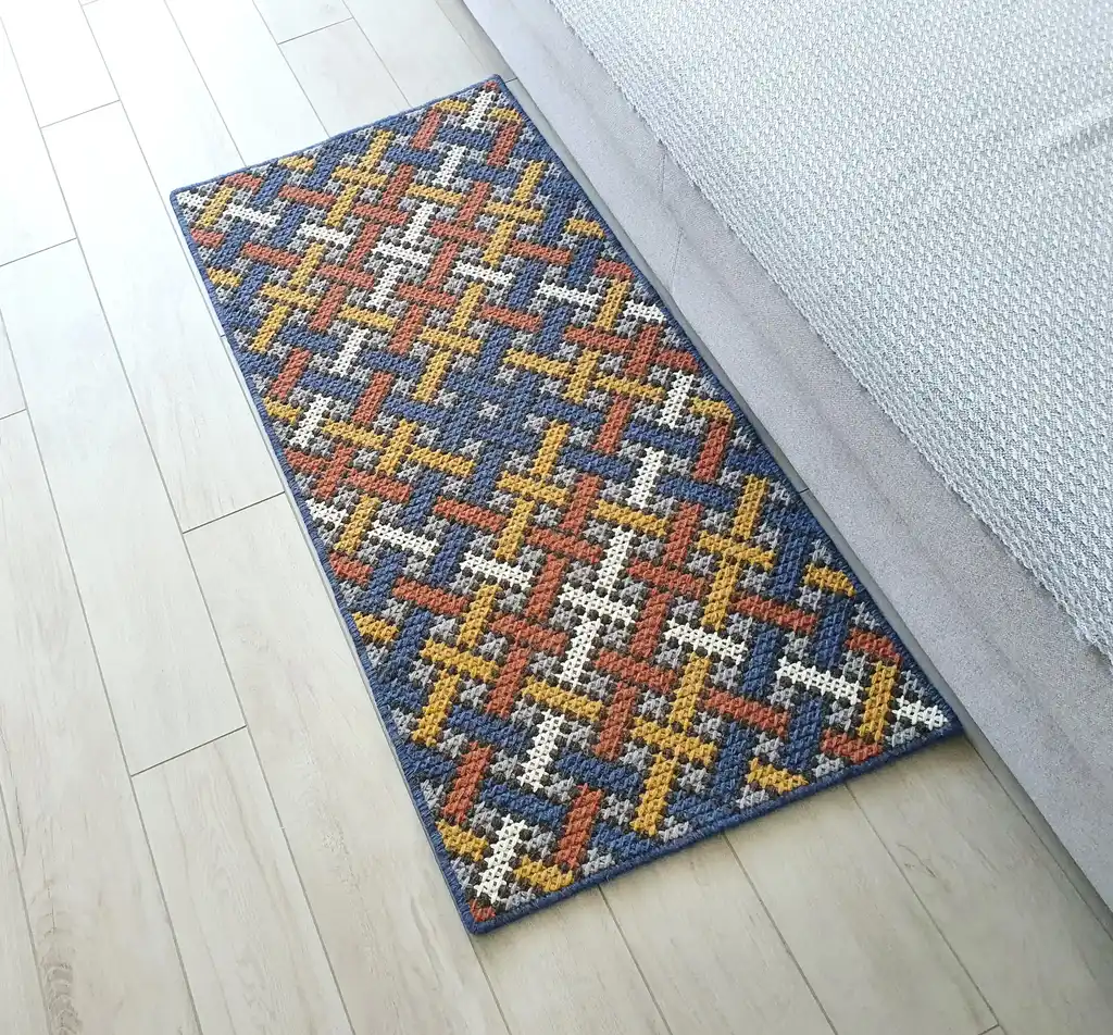 Handcrafted cross-stitch rug made from wool and felt, showcasing intricate embroidery patterns.