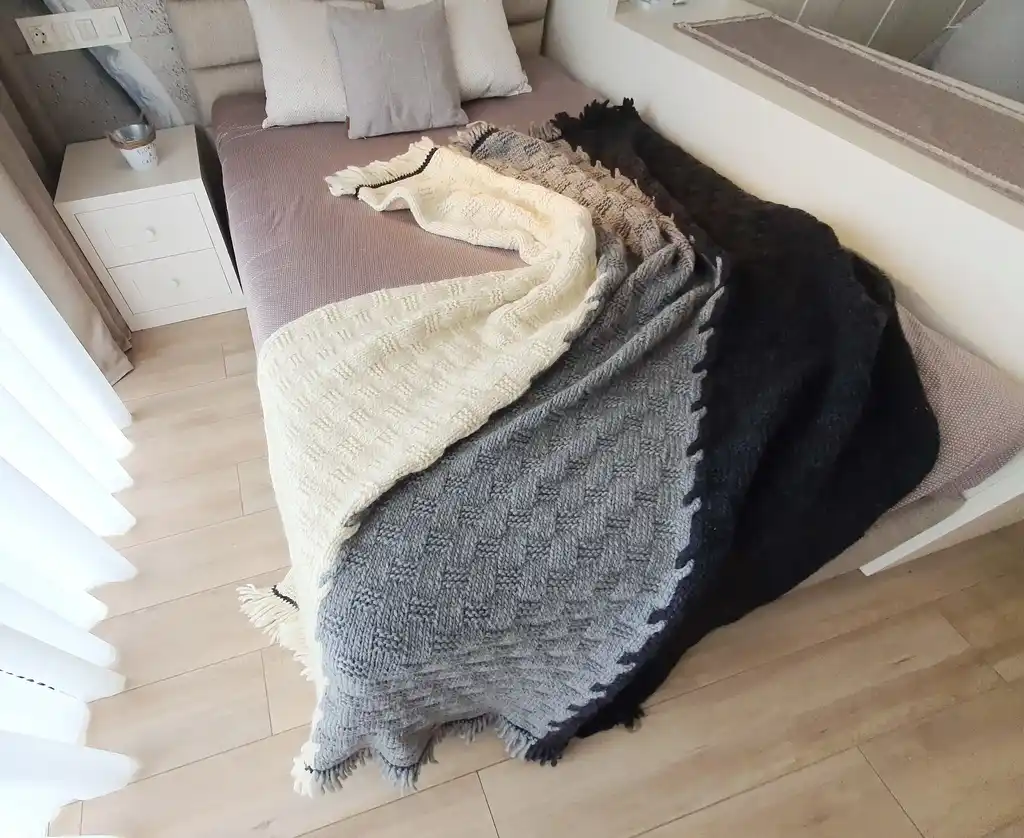 luxury merino wool knitted throw blanket in natural color, showing soft texture and quality craftsmanship.