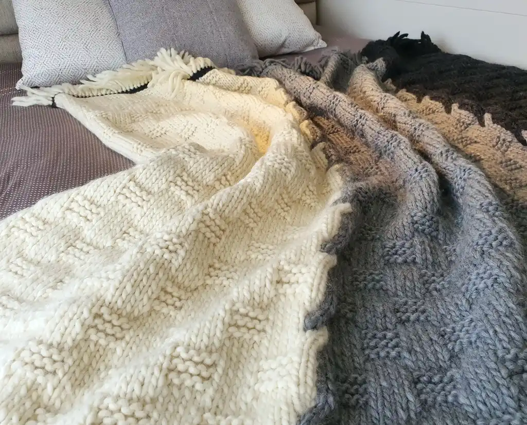 luxury merino wool knitted throw blanket in natural color, showing soft texture and quality craftsmanship.