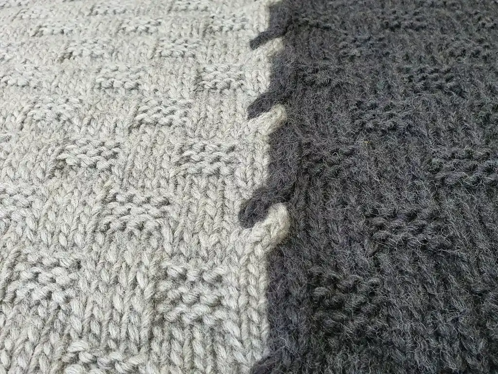 luxury merino wool knitted throw blanket in natural color, showing soft texture and quality craftsmanship.