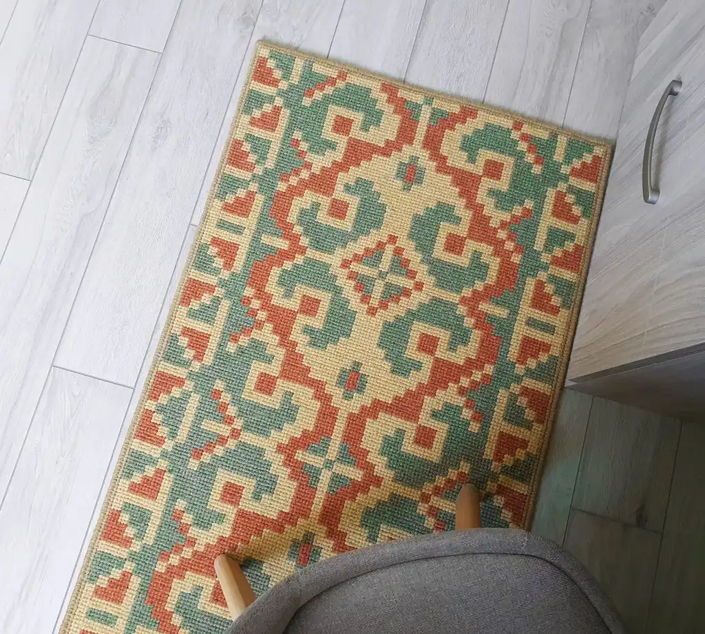 handcrafted wool rug with traditional embroidery pattern.