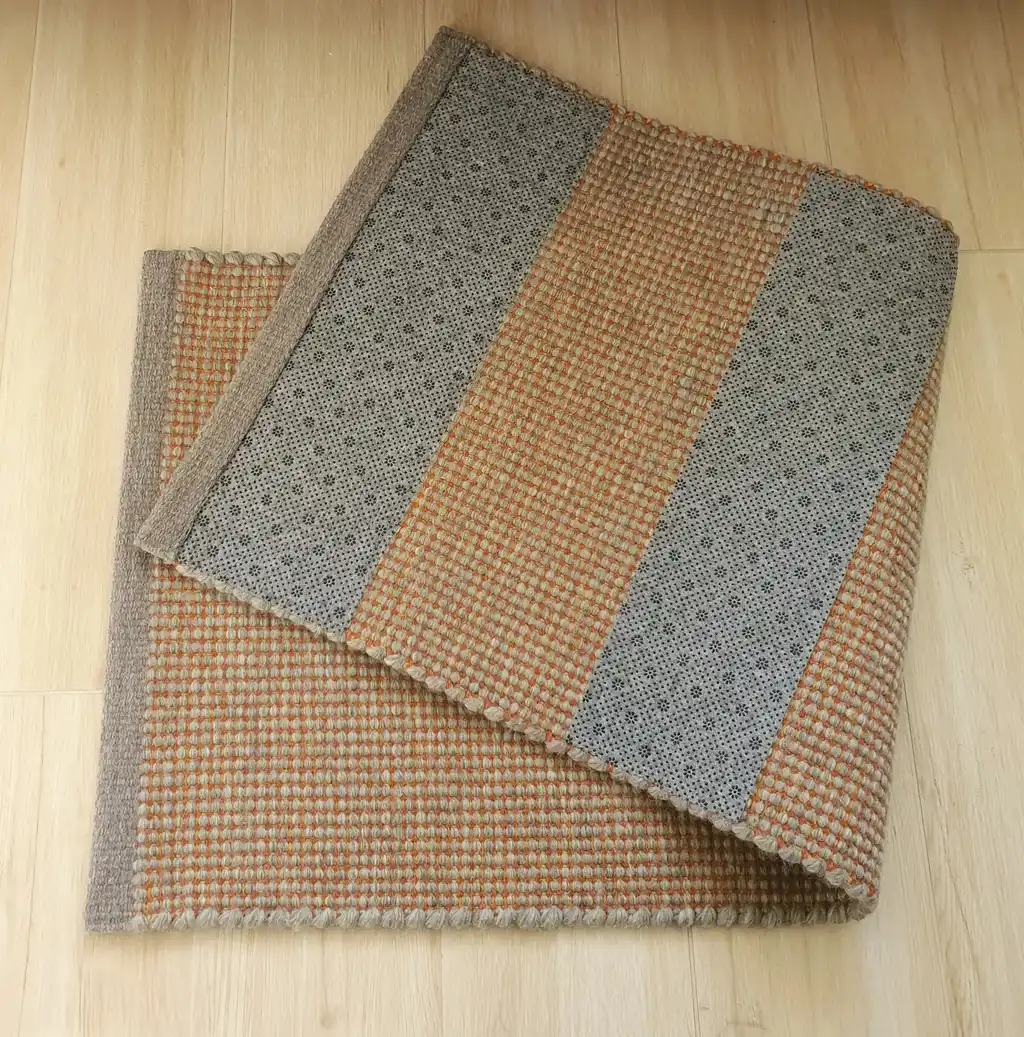 handwoven chunky wool rug in natural colors, traditional weaving technique.