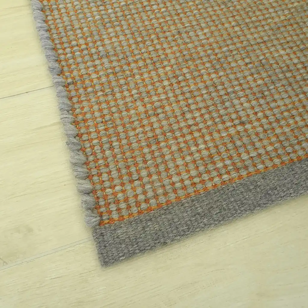 handwoven chunky wool rug in natural colors, traditional weaving technique.
