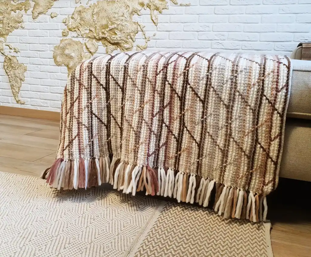 Handmade crochet blanket in merino wool with intricate patterns.
