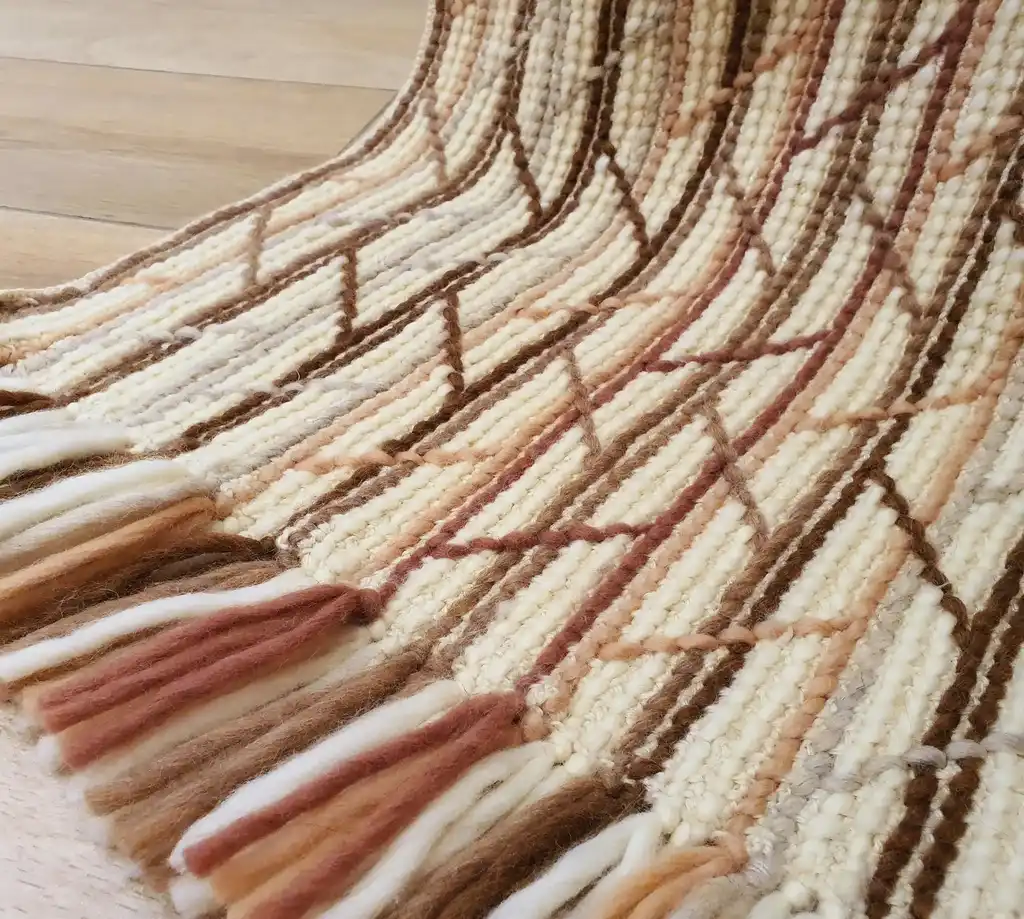 Handmade crochet blanket in merino wool with intricate patterns.