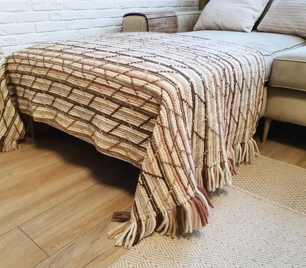 Handmade crochet blanket in merino wool with intricate patterns.