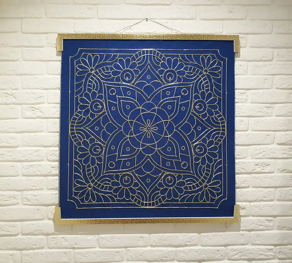 handcrafted embroidered hanging decoration with lurex cord on felt background.