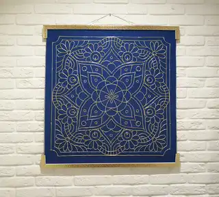 handcrafted embroidered hanging decoration with lurex cord on felt background.