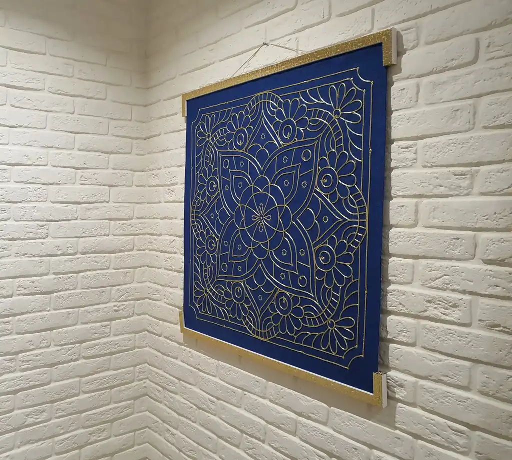 handcrafted embroidered hanging decoration with lurex cord on felt background.