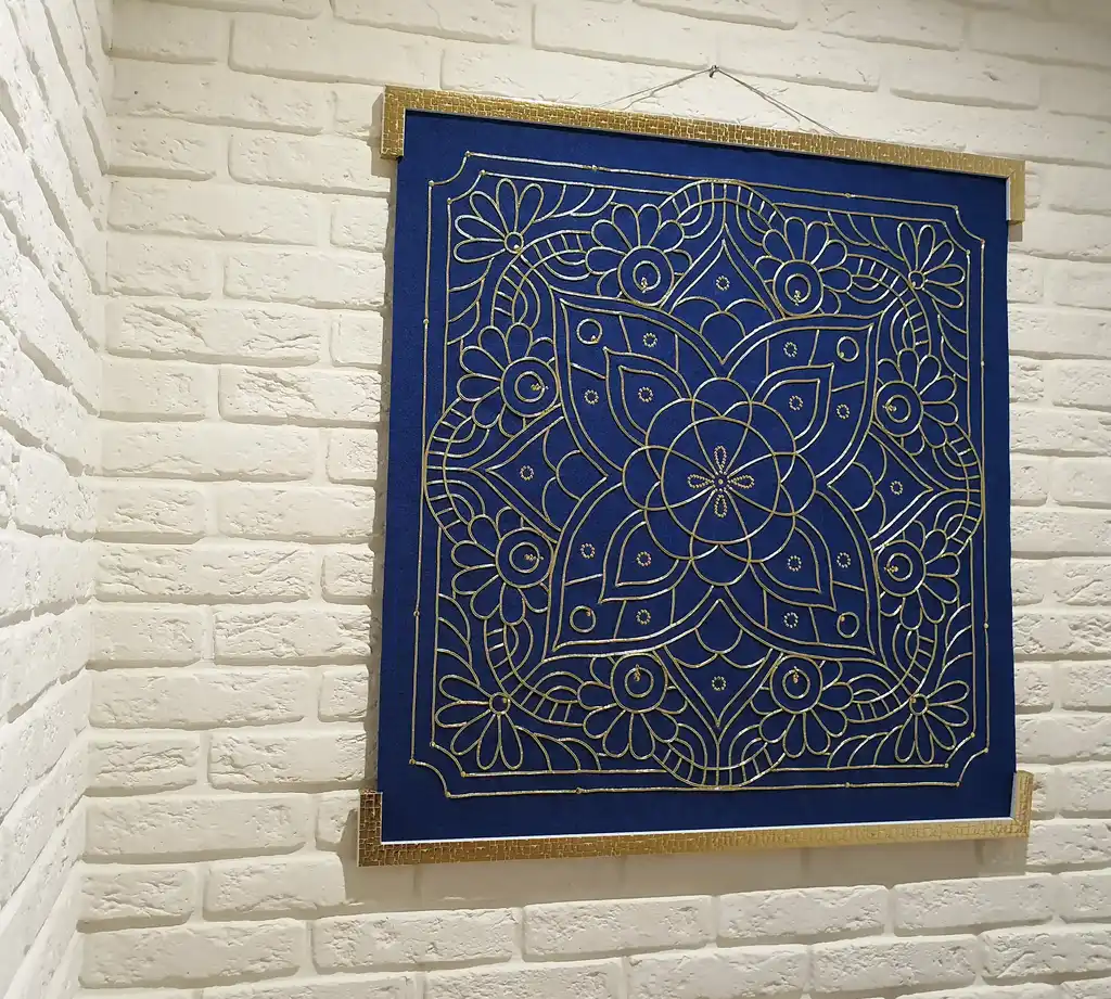 handcrafted embroidered hanging decoration with lurex cord on felt background.