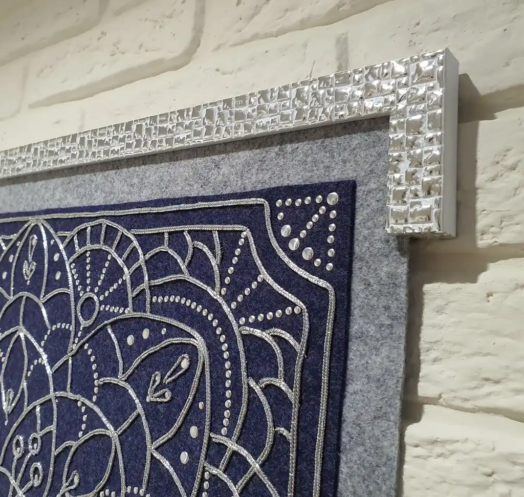 Handcrafted embroidered felt wall hanging with shimmering lurex cord decoration.