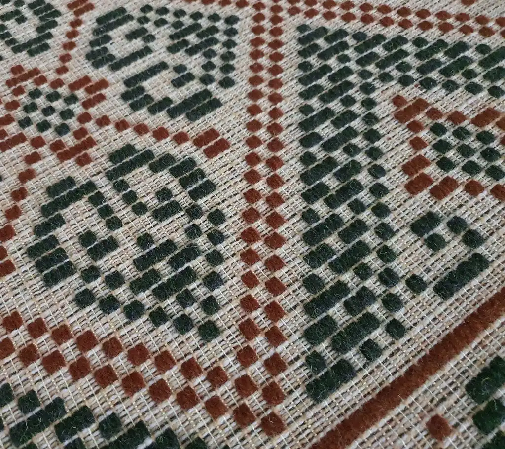 handwoven wool rug with traditional Ukrainian viburnum flower patterns in red and natural colors.
