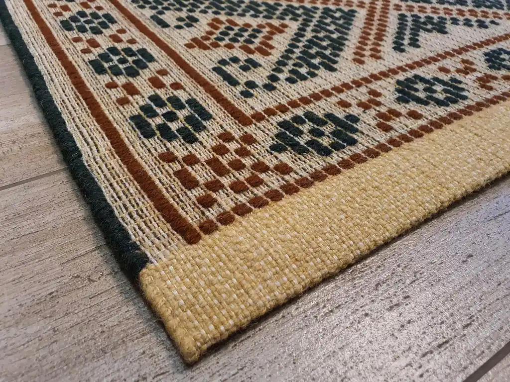 handwoven wool rug with traditional Ukrainian viburnum flower patterns in red and natural colors.